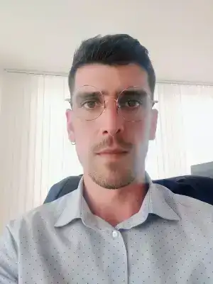 Diogo Ferreira avec des lunettes rondes et une chemise bleue à pois...